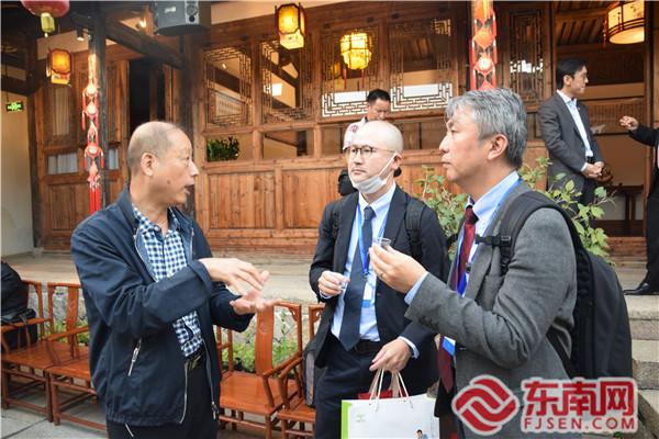 傳統(tǒng)茉莉花茶窨制工藝非物質(zhì)文化遺產(chǎn)項(xiàng)目代表性傳承人王德星（左一）向外國駐華使節(jié)介紹福州茉莉花茶